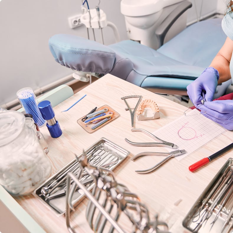Dental tools and equipment on the table near a dental chair.