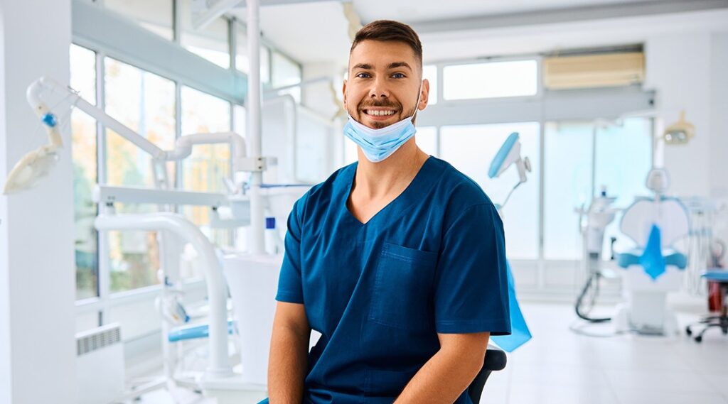 Smiling dental professional in treatment room demonstrating warm approachable patient care