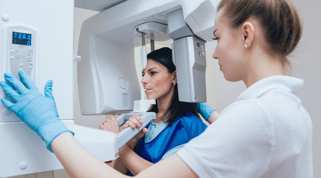 Dental professional using modern digital imaging technology with patient showing advanced treatment capabilities