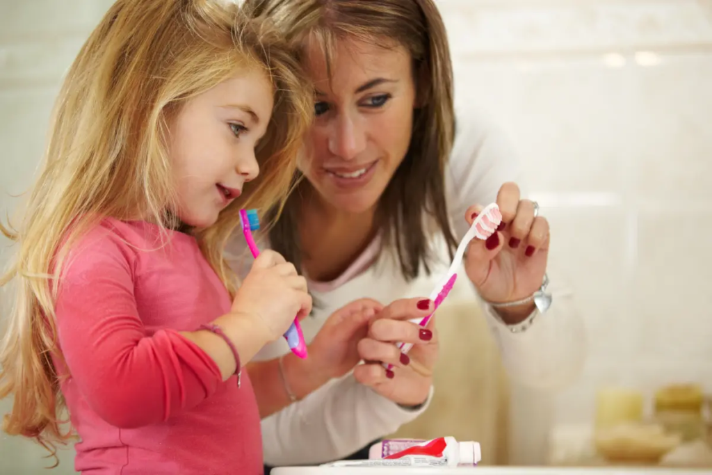 SEO for pediatric dentists: A child learns to brush her teeth.