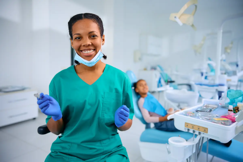 SEO for pediatric dentists: A smiling pediatric dentist prepares to assist her patient.